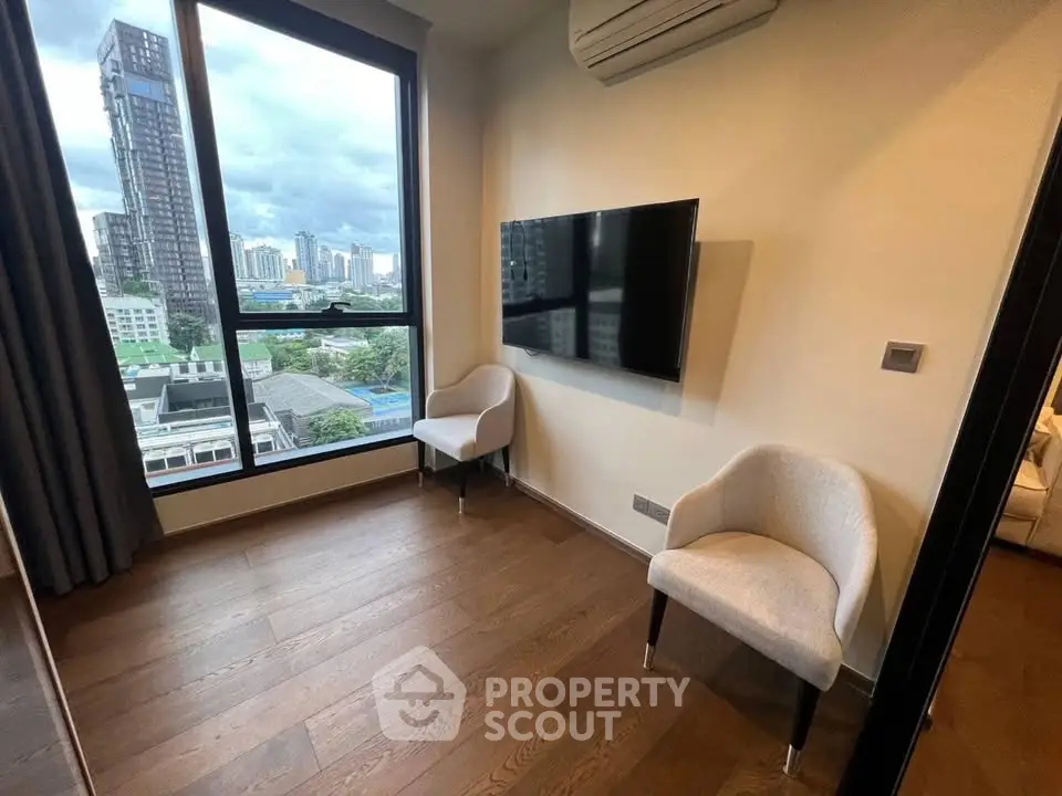 Modern room with large window and city view, featuring wall-mounted TV and air conditioning.