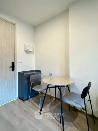 Cozy corner dining area with modern table and chairs in minimalist apartment.