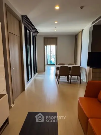 Modern living room with dining area and balcony view in a stylish apartment.