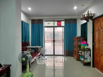 Spacious living room with large windows and modern decor, perfect for family gatherings.