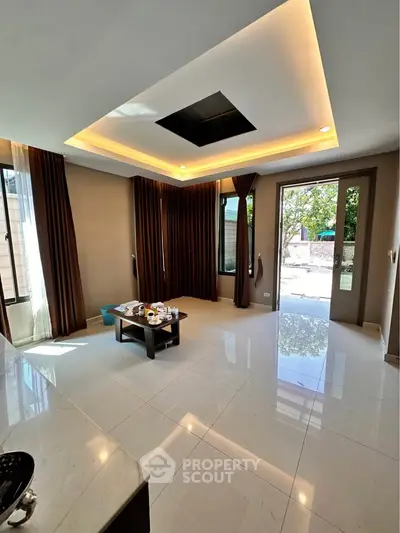 Spacious modern living room with large windows and elegant ceiling design