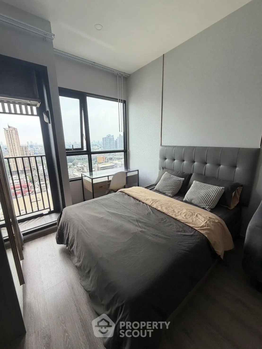Modern bedroom with city view and stylish decor in high-rise apartment
