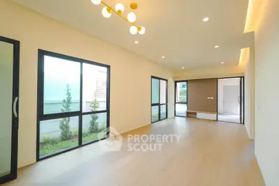 Spacious modern living room with large windows and elegant lighting in a contemporary home.