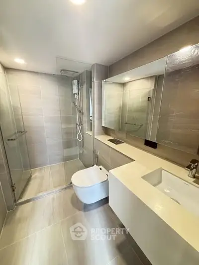 Modern bathroom with sleek design, glass shower, and elegant fixtures in a contemporary home.