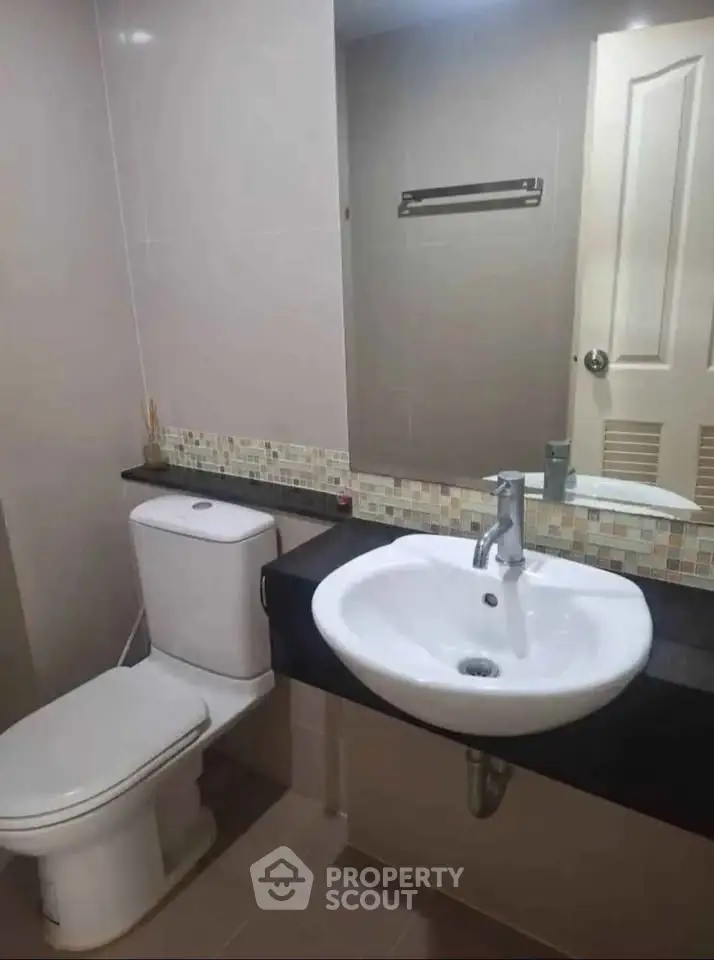 Modern bathroom with sleek fixtures and elegant tile accents.