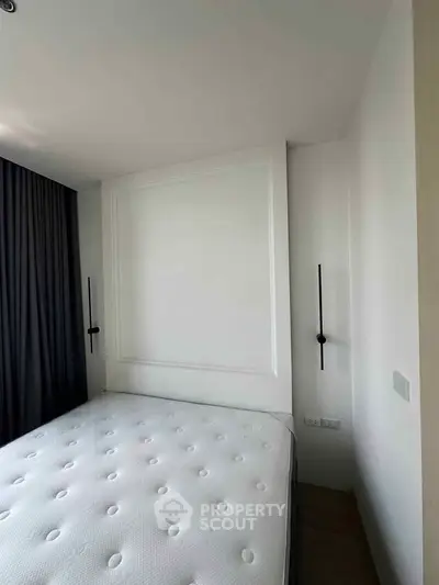 Modern bedroom with minimalist design and large window for natural light.