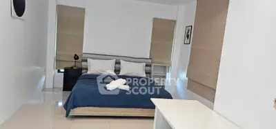 Spacious bedroom with modern decor and natural light, featuring a comfortable bed and stylish furnishings.