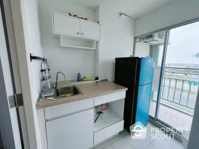 Compact kitchen with modern appliances and balcony view