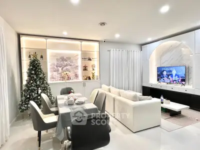 Modern living room with elegant decor, featuring a cozy white sofa, stylish dining area, and festive Christmas tree.