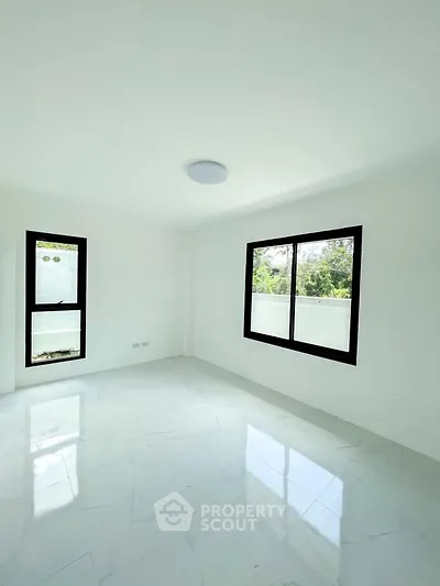 Bright and spacious empty room with large windows and glossy white flooring, perfect for customization.