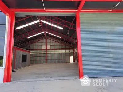 Spacious industrial warehouse with high ceilings and red steel framework