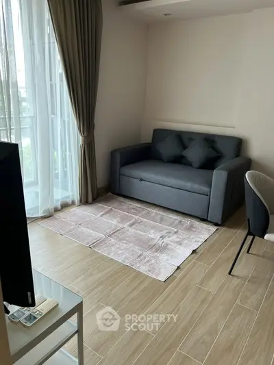 Modern living room with stylish sofa and floor-to-ceiling windows, perfect for urban living.