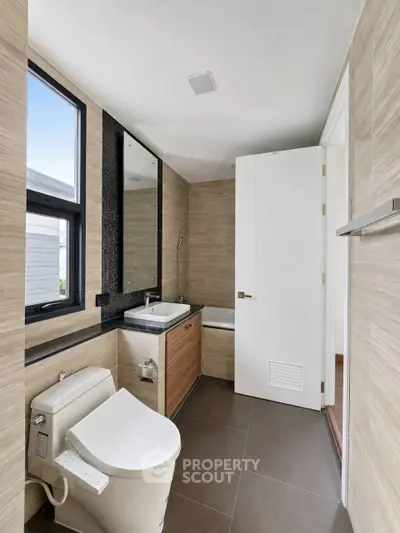 Modern bathroom with sleek design, featuring a bathtub and contemporary fixtures.