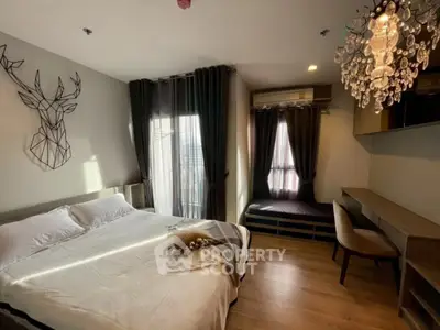 Modern bedroom with elegant chandelier and stylish decor in a cozy apartment.