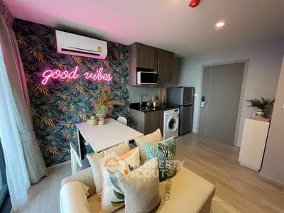Chic living room with neon sign, modern kitchen, and cozy seating area.