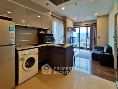 Modern open-layout kitchen with appliances and living room view in high-rise apartment