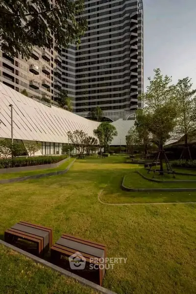 Luxurious high-rise building with lush landscaped garden and modern architecture.