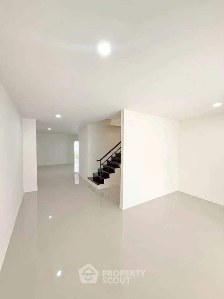 Spacious modern interior with sleek staircase and glossy floors, perfect for contemporary living.