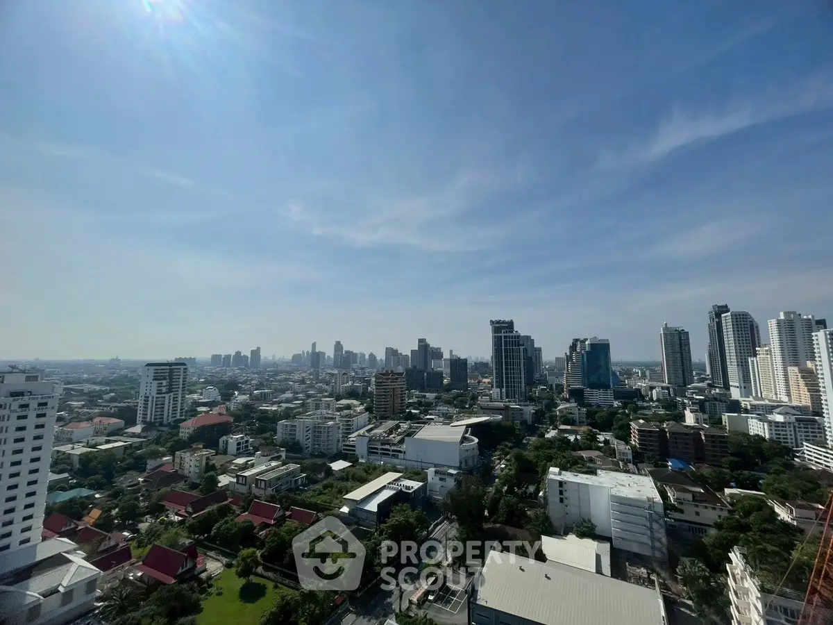 Stunning cityscape view from high-rise building showcasing urban skyline and greenery.