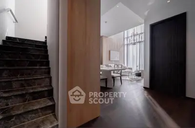 Luxurious modern interior with elegant staircase and spacious living area, featuring high ceilings and chic decor.