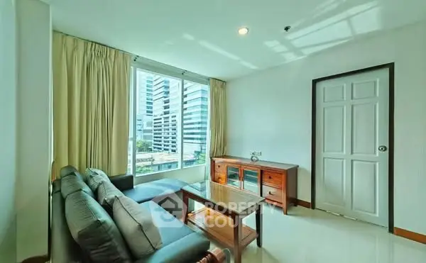 Bright living room with city view, modern furniture, and large windows.
