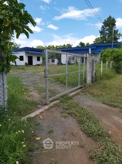 Charming rural property with gated entrance and lush greenery, perfect for serene living.