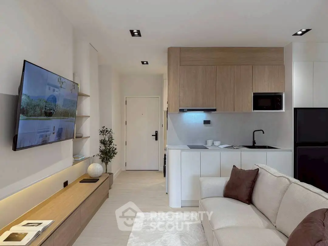 Modern living room with open kitchen, sleek design and cozy ambiance.