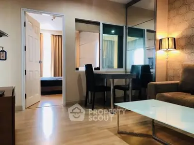 Modern living room with stylish decor and open view to bedroom, featuring elegant furniture and warm lighting.