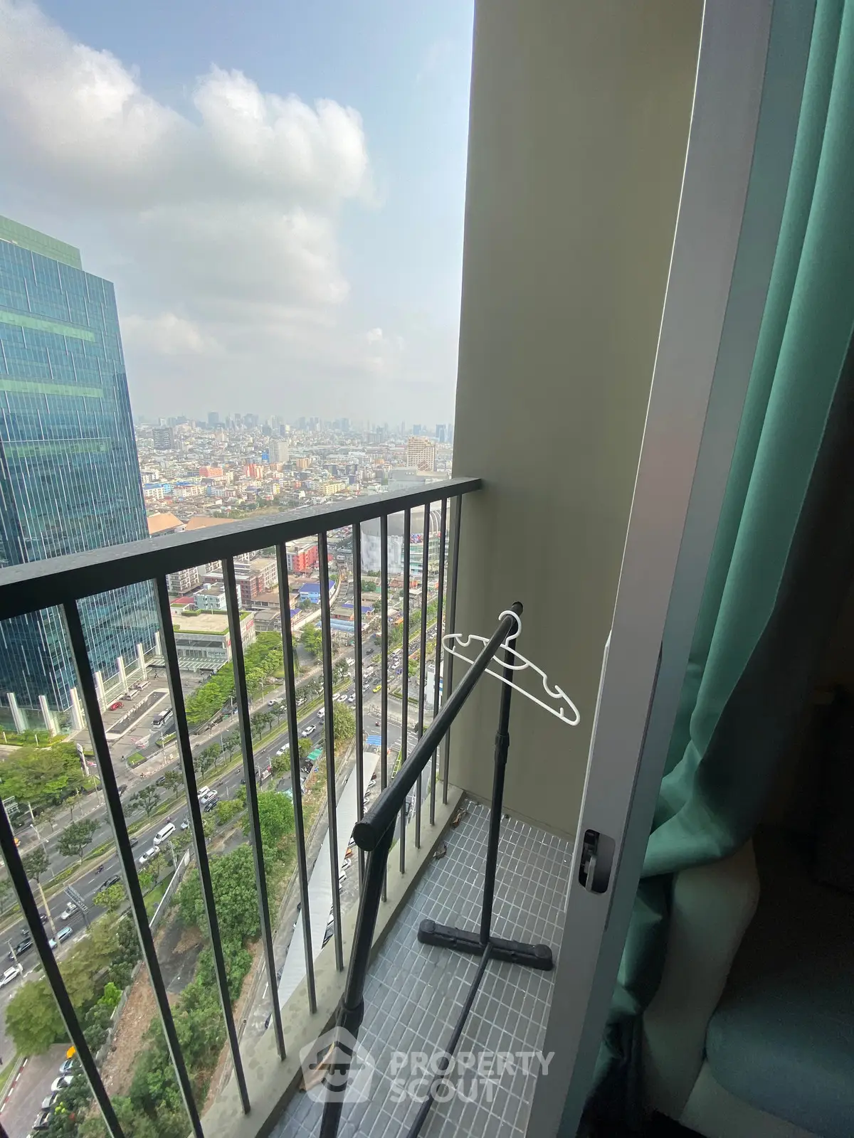 Stunning city view from a high-rise balcony with modern railing and urban skyline.