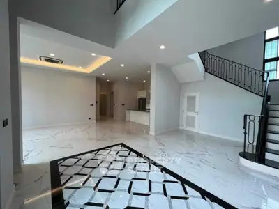 Spacious modern living room with elegant staircase and marble flooring