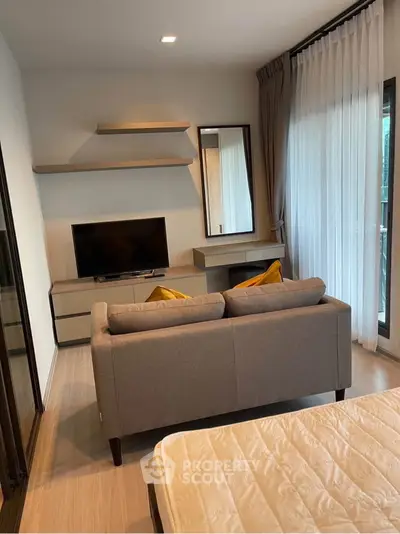 Modern living room with cozy sofa, TV, and elegant decor in a bright apartment.