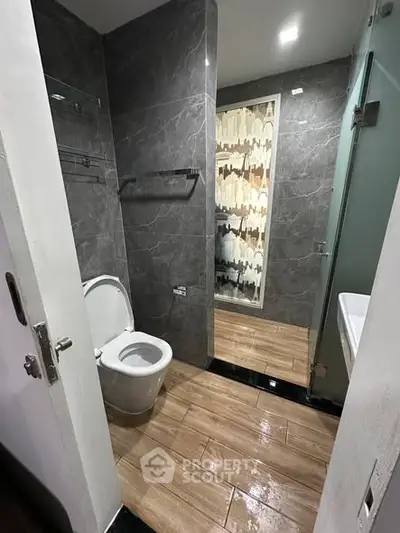 Modern bathroom with sleek gray tiles and wooden flooring