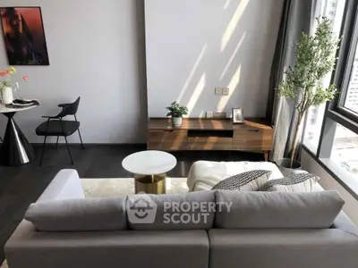 Modern living room with stylish furniture and large windows offering natural light.