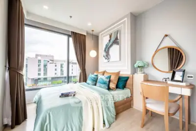 Modern bedroom with large window and stylish decor in a contemporary apartment.