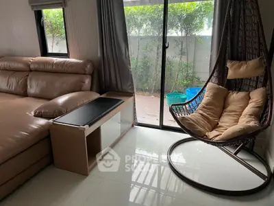 Cozy living room with modern sofa and hanging chair, perfect for relaxation.