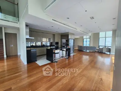 Spacious open-plan kitchen and living area with modern design and hardwood floors.