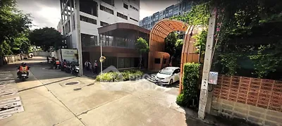Modern building entrance with unique architectural design and lush greenery