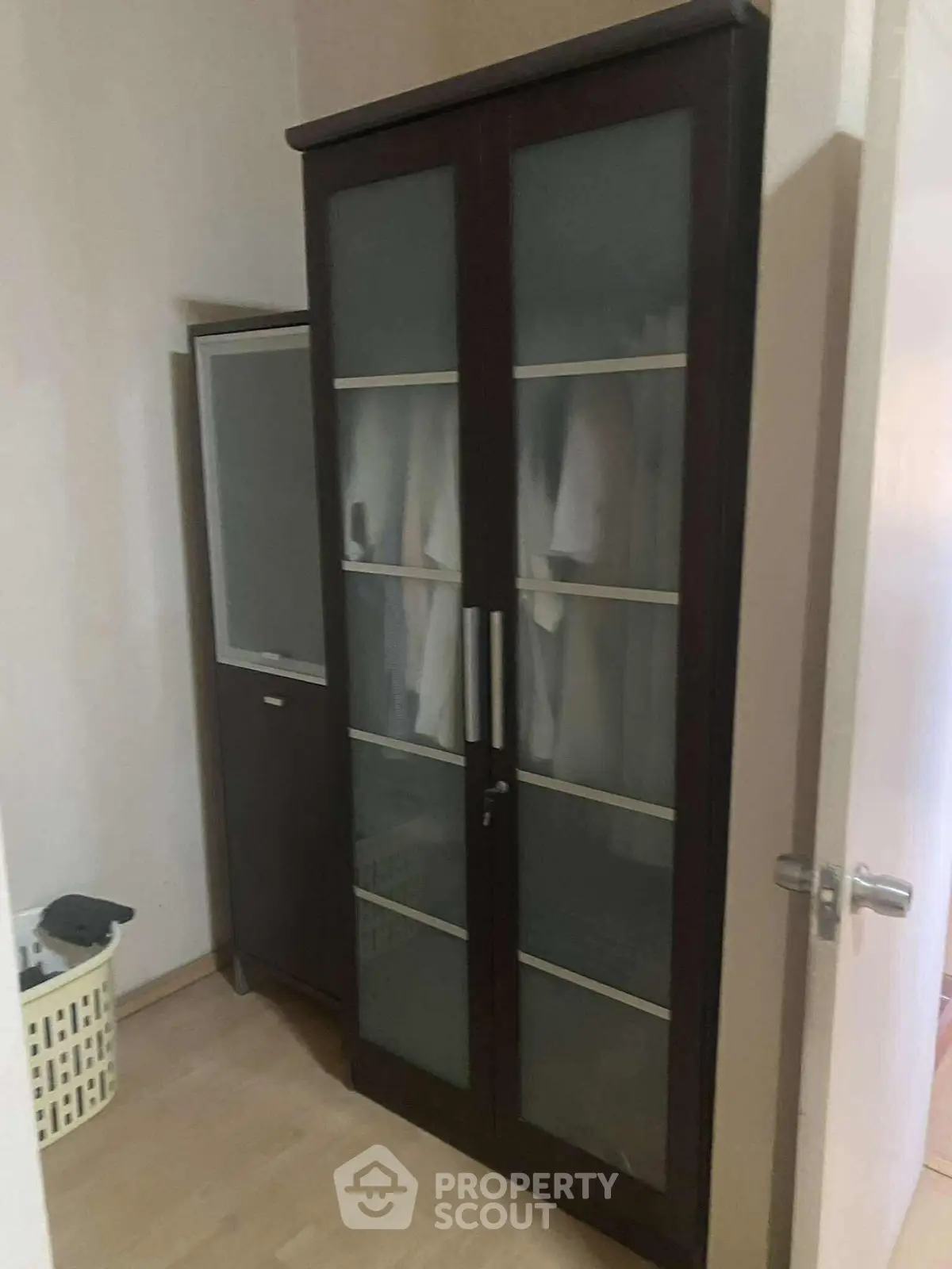 Stylish storage cabinet with frosted glass doors in a modern interior space.