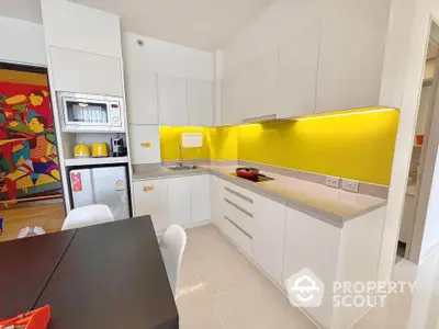 Modern kitchen with vibrant yellow backsplash and sleek white cabinetry