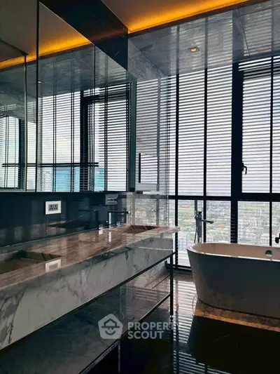 Luxurious bathroom with city view, featuring marble countertops and a freestanding bathtub.