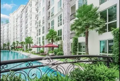 Luxurious apartment complex with poolside view and lush greenery