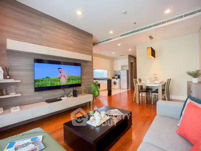 Spacious modern living room with open kitchen and dining area, featuring stylish decor and hardwood floors.