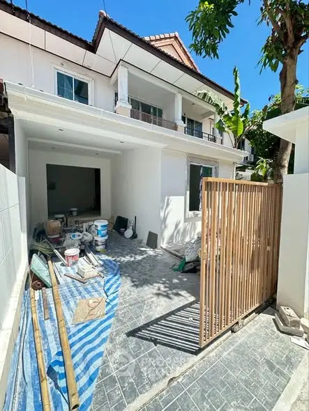 Charming townhouse under renovation with modern exterior and spacious front area.