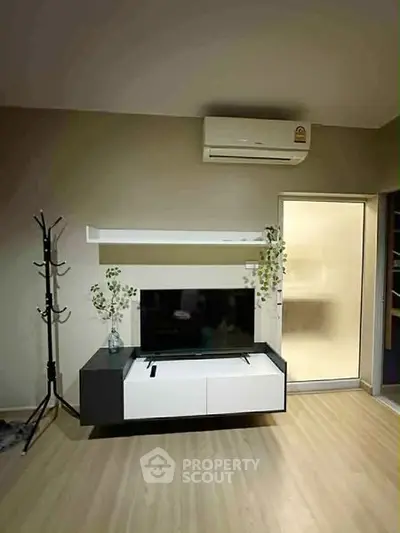 Modern living room with sleek TV stand and air conditioning unit.
