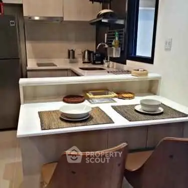 Modern kitchen with sleek design and dining area in a cozy apartment.