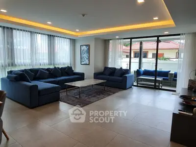 Spacious modern living room with large windows and elegant furnishings.