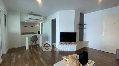 Modern living room with sleek design and wooden flooring, featuring a TV and air conditioning.