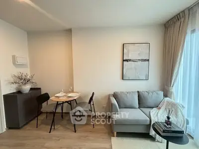Modern living room with cozy sofa and dining area, featuring elegant decor and natural light.