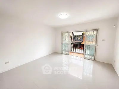Spacious empty living room with large windows and balcony access, perfect for customization.