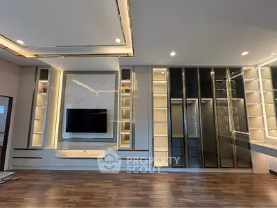 Luxurious modern living room with built-in shelves and sleek TV setup, perfect for stylish entertainment.